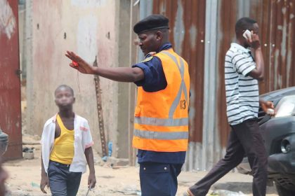Un agent de la Police de Circulation Routière régule la circulation sur la route à Kinshasa. Ph. 2025